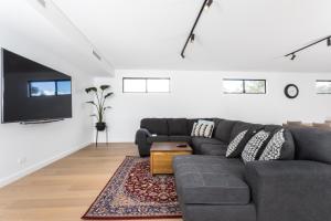 a living room with a gray couch and a flat screen tv at Bluff Street Home by the BnB Collection in Albany