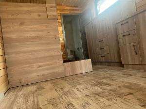 a bathroom with a large wooden door in a room at Cãbãnuţe - Lac Maleia in Dobreşti