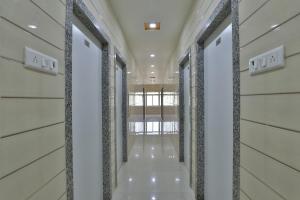 um corredor num edifício com paredes e colunas brancas em OYO Hotel Balaji Inn em Hālol