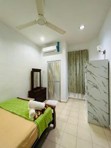 a bedroom with a bed and a ceiling fan at Homestay Ira Jaya - 4 Unit Rumah in Kangar