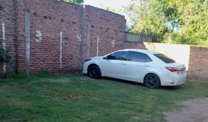a white car parked next to a brick wall at Departamento Falucho 2 in Santa Rosa
