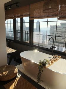 a bath tub in a bathroom with a large window at Great Exodus - Iasi City Center in Iaşi