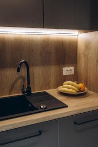 a counter with a sink and a plate of bananas at Great Exodus - Iasi City Center in Iaşi