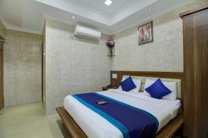 a bedroom with a large bed with blue pillows at OYO The Park Royal in Chennai