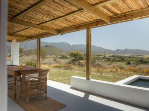 a patio with a table and a view of the mountains at Middelpunt Branch in Robertson