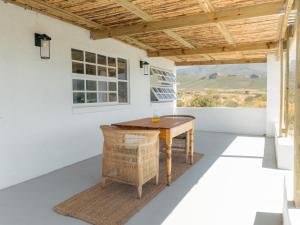 a patio with a table and a window at Middelpunt Branch in Robertson