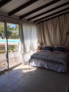 a bedroom with a bed and a large window at Joli pavillon individuel in Carry-le-Rouet