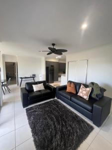 a living room with a black couch and a black rug at Upper Coomera Castle 2 in Gold Coast