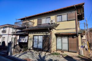 an apartment building with windows and a balcony at Yoshimura igariya in Azagawa