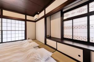 um quarto com uma cama e duas janelas em Yoshimura igariya em Azagawa