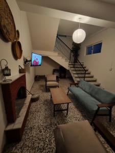 een woonkamer met een bank, een tv en een trap bij Limnitis Traditional House in Limnitis
