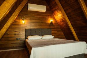 ein Schlafzimmer mit einem Bett im hölzernen Dachgeschoss in der Unterkunft Alis Paradise Sapanca in Sapanca