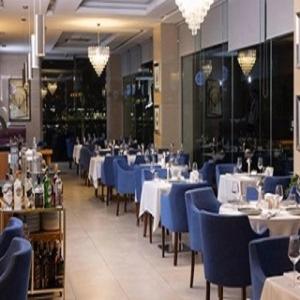 una sala da pranzo con tavoli, sedie e sedie blu di Anemon Ordu a Ordu