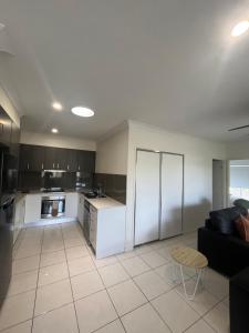 a kitchen with white appliances and a couch in a room at Upper Coomera Castle 2 in Gold Coast