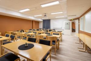 een leeg klaslokaal met tafels en stoelen en een whiteboard bij Hotelli Visiitti in Ylivieska