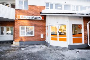 a building with a sign on the side of it at Hotelli Visiitti in Ylivieska
