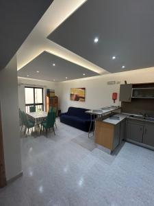 a kitchen and living room with a couch and a table at No 6 Poseidon Apartment in St Julian's
