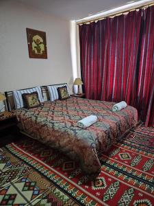 um quarto com uma cama grande e cortinas vermelhas em Rocky Mountains Hotel em Wadi Musa