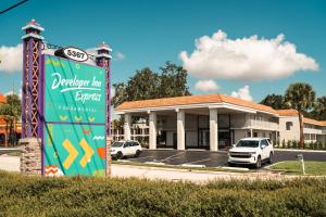 a sign in front of a building with a car dealership at Developer Inn Express Fundamental, a Travelodge by Wyndham in Kissimmee