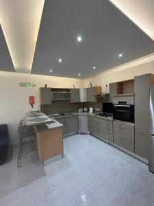 a large kitchen with stainless steel appliances and gray cabinets at No 6 Poseidon Apartment in St Julian's