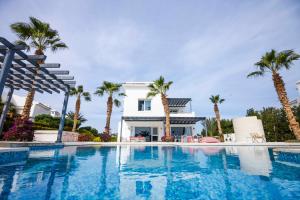 - une piscine en face d'une maison avec des palmiers dans l'établissement El Gouna Elite Villa's & Apartment's Private Residence with Sea & Garden View's - Hurghada, à Hurghada
