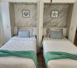 2 Einzelbetten in einem Zimmer mit Handtüchern darauf in der Unterkunft Coral Resort D4 in Clearwater Beach