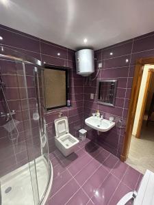 a purple bathroom with a toilet and a sink at No 6 Poseidon Apartment in St. Julianʼs