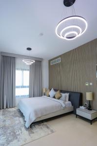 - une chambre avec un grand lit blanc et deux lampes dans l'établissement The Wave Villa - Fujairah, à Fujaïrah