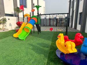 a playground with slides and play equipment on the grass at The Wave Villa - Fujairah in Fujairah