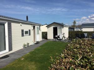 a house with a bike parked in a yard at Meerchalets in Biggekerke