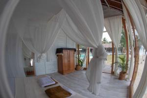 a bedroom with a bed with white curtains at La Belle Hollow Trees in Katiet