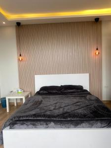 1 dormitorio con 1 cama grande con manta negra en Dolunay jarash, en Jerash