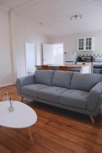 a living room with a blue couch and a table at UrbanNook - Heart of the city in Brisbane