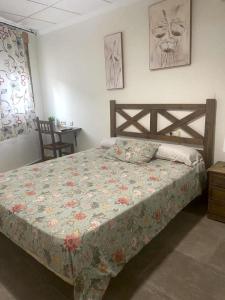 1 dormitorio con 1 cama con edredón de flores en Ca' La Conchin, en Cortez de Pallas