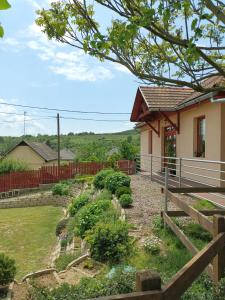 uma casa com uma cerca e um jardim em Napfénydomb Vendégház em Mátraszele