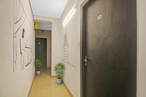 un couloir avec une porte et deux plantes en pot dans l'établissement OYO The Jumbo Stay, à Ālīpur