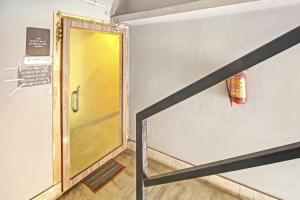 une porte jaune dans une pièce avec un escalier dans l'établissement OYO The Jumbo Stay, à Ālīpur