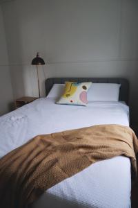 a white bed with a pillow on top of it at UrbanNook - Heart of the city in Brisbane