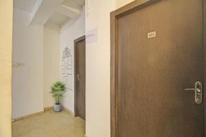 une porte dans un couloir avec une plante en pot dans l'établissement OYO The Jumbo Stay, à Ālīpur