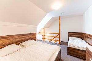 1 dormitorio con 2 camas y escalera en Apartmany Kouty, en Loučná nad Desnou