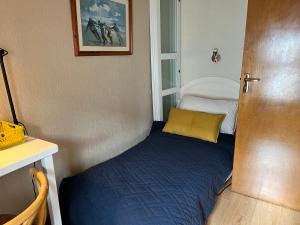 een klein bed in een kleine kamer met een deur bij Hideaway Cottage in Schull