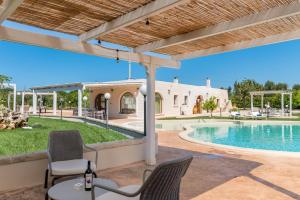 奥斯图尼Hasamami Eco Trullo, Ostuni luxury suite的带椅子的露台和游泳池