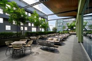 un patio con mesas y sillas en un edificio en VIVERE Hotel, ARTOTEL Curated en Tangerang