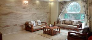 a living room with two couches and a window at Peninsula drive lake side apartments in Kampala