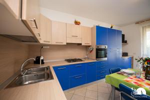 una cocina con armarios azules y fregadero en Casa Blu, en Toscolano Maderno