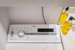 a washing machine with two bottles of yellow detergent at Apartment near Buivydiškės lakes in Vilnius