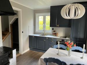 una cocina con armarios negros y una mesa con flores en Private guesthouse close to nature and the sea en Vaxholm