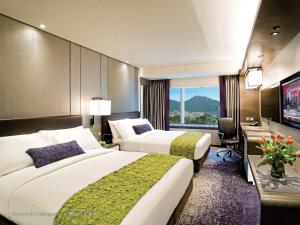 a hotel room with two beds and a television at Royal Plaza Hotel in Hong Kong