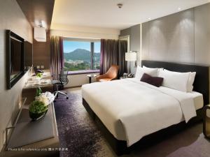 ein Hotelzimmer mit einem großen weißen Bett und einem Fenster in der Unterkunft Royal Plaza Hotel in Hongkong