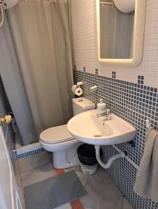a bathroom with a white toilet and a sink at Santillana terrazas in Seville